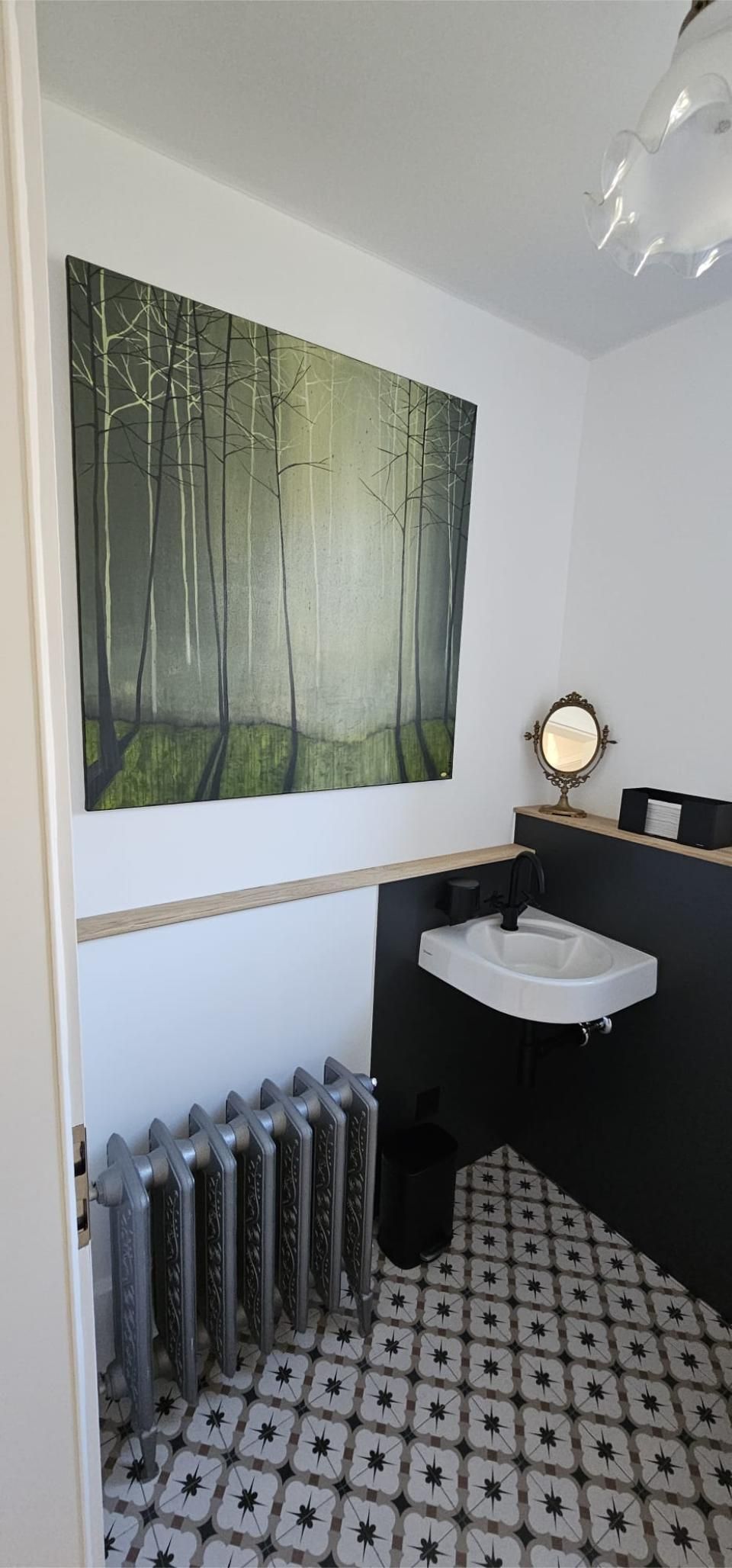 Ein Badezimmer mit einem Waschbecken und einem Gemälde an der Wand. Foto von der MS Sanitär Heizung GmbH