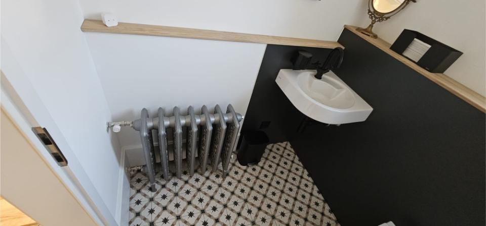 Ein Badezimmer mit Waschbecken, Heizkörper und Spiegel. Foto von der MS Sanitär Heizung GmbH