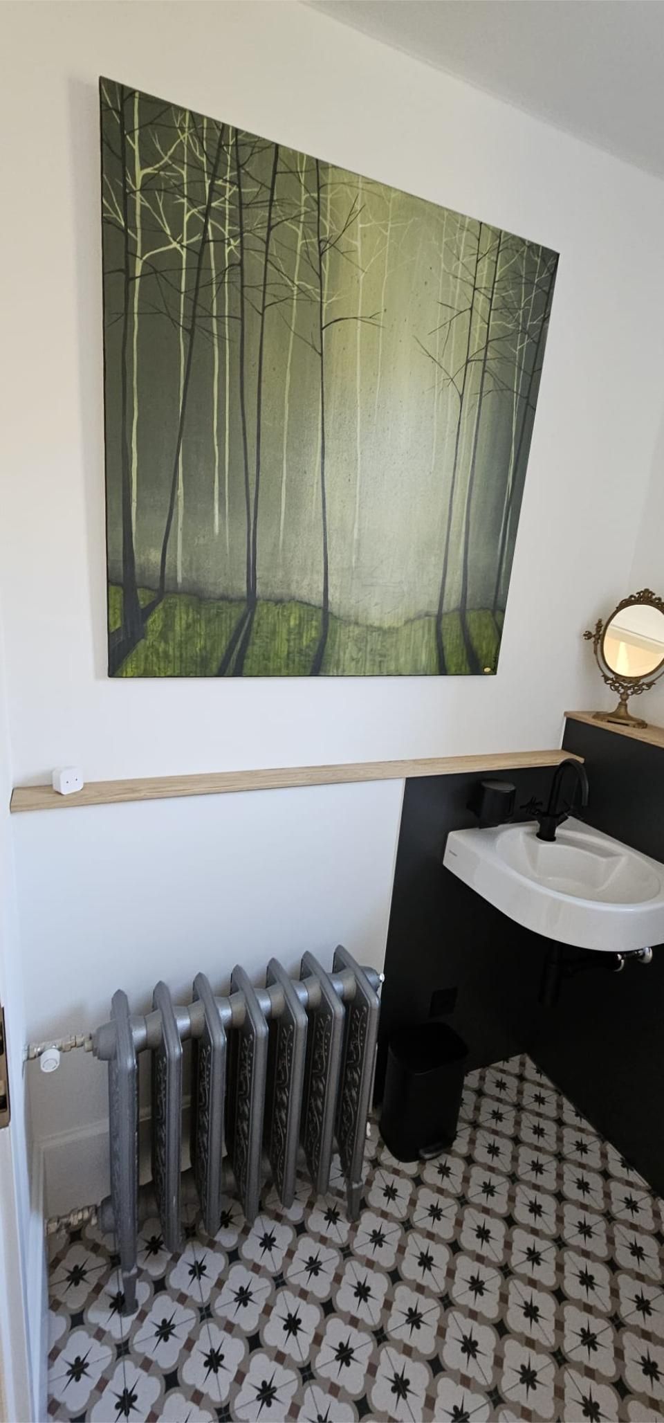 Ein Badezimmer mit einem Waschbecken und einem Gemälde an der Wand darüber. Foto von der MS Sanitär Heizung GmbH