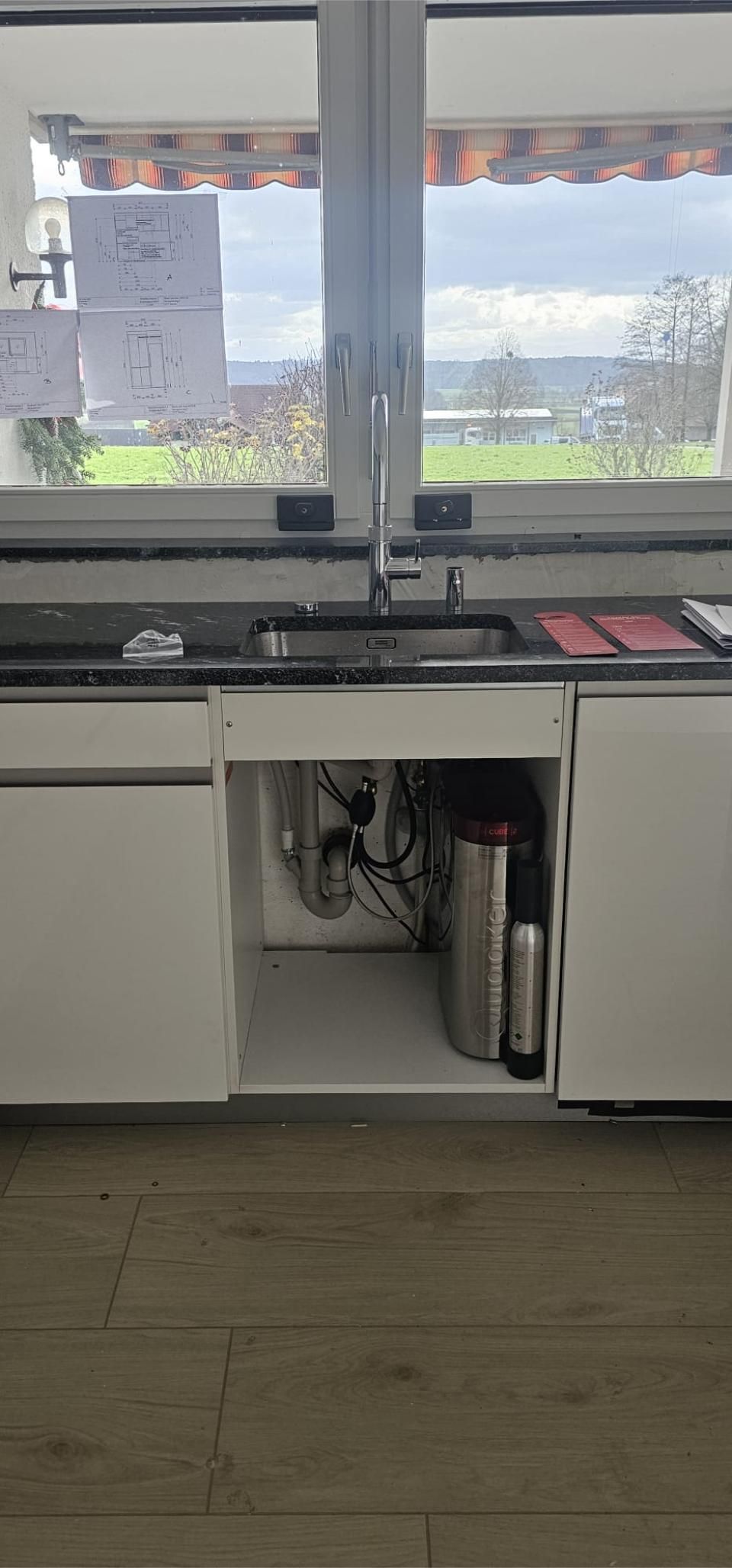 Eine Küche mit Spüle, Schränken und Fenster. Foto von der MS Sanitär Heizung GmbH