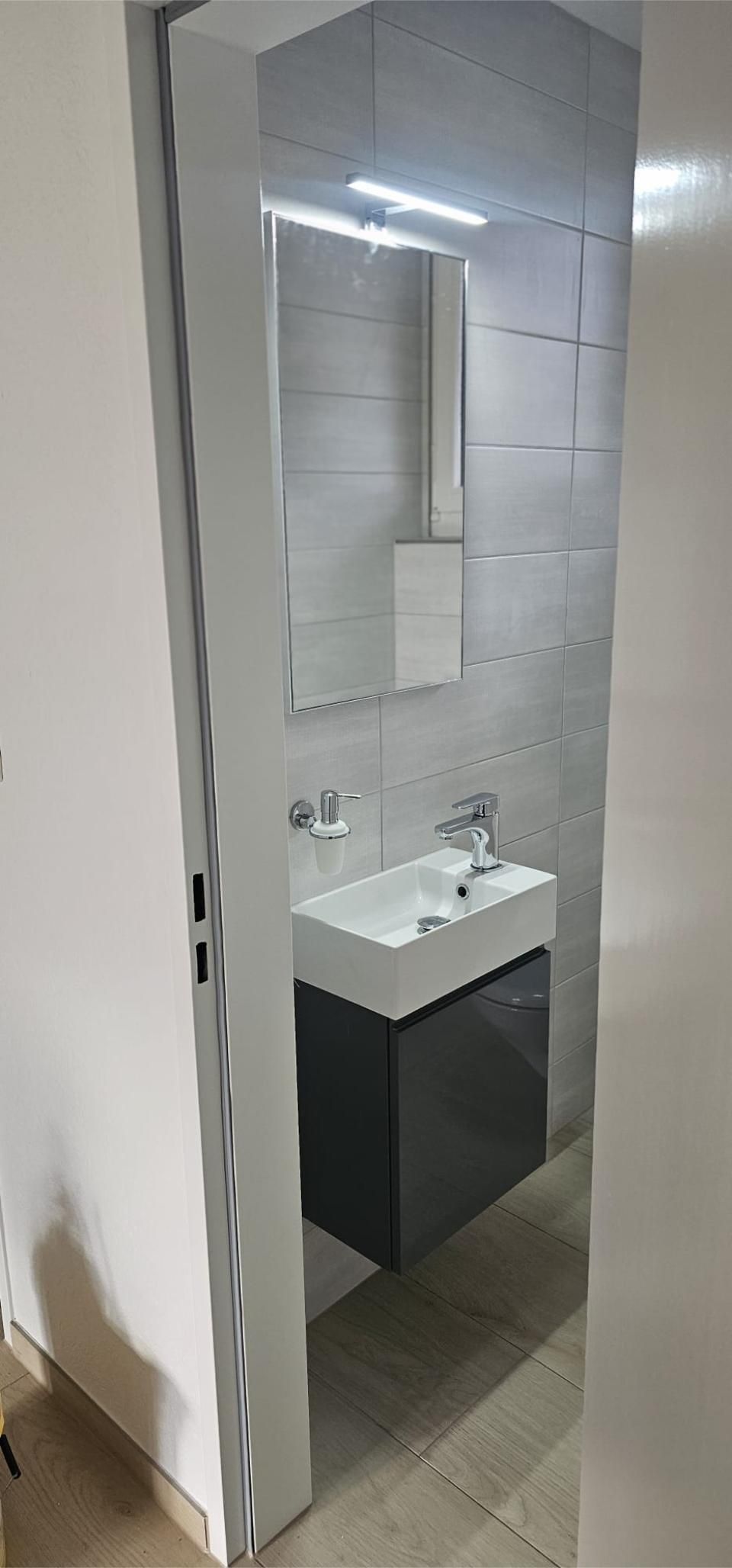 Ein Badezimmer mit Waschbecken, Spiegel und Schrank. Foto von der MS Sanitär Heizung GmbH