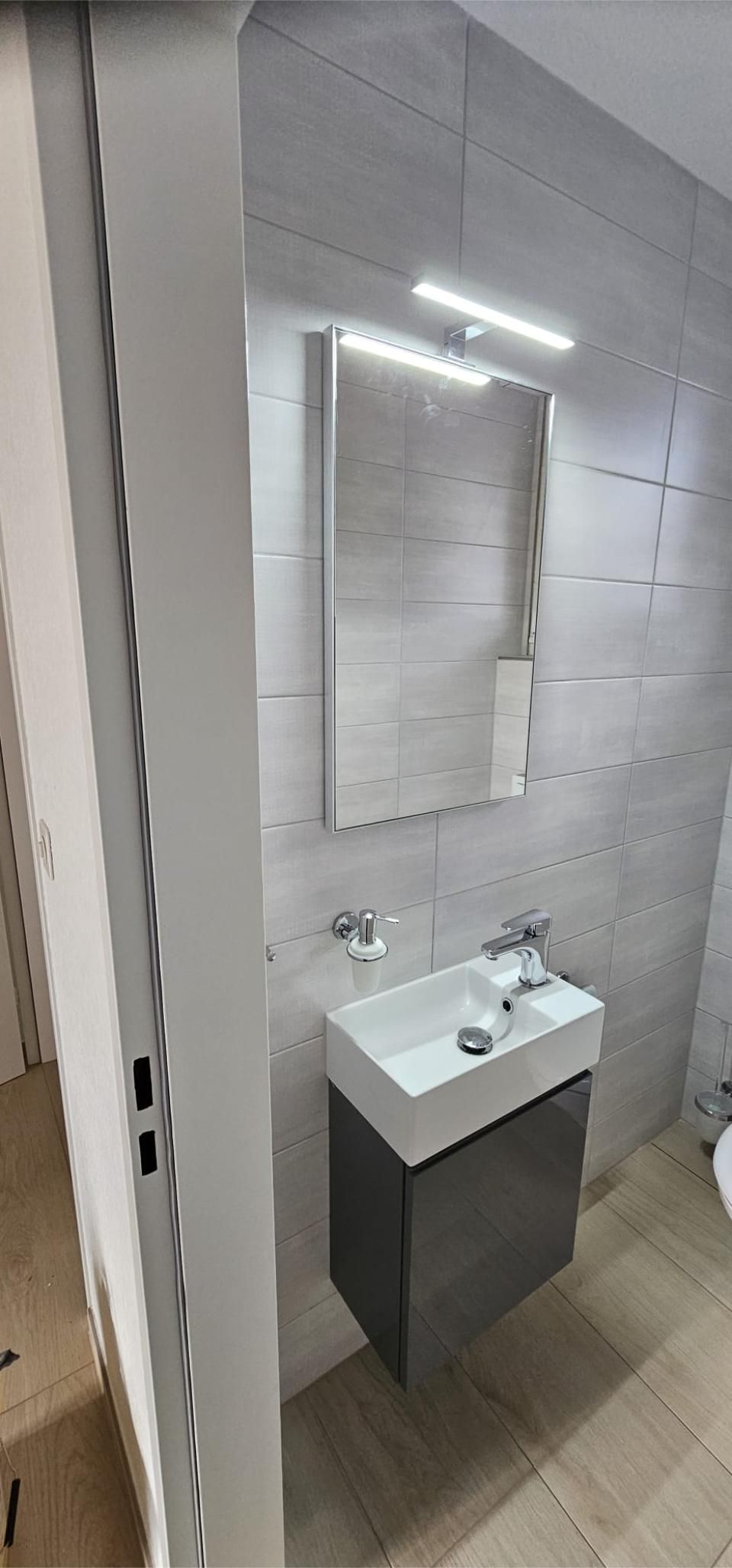 Ein Badezimmer mit Waschbecken, Spiegel und Toilette. Foto von der MS Sanitär Heizung GmbH