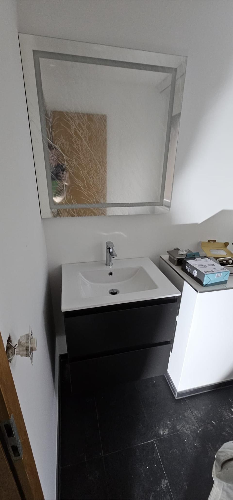 Ein Badezimmer mit einem Waschbecken und einem Spiegel darin. Foto von der MS Sanitär Heizung GmbH