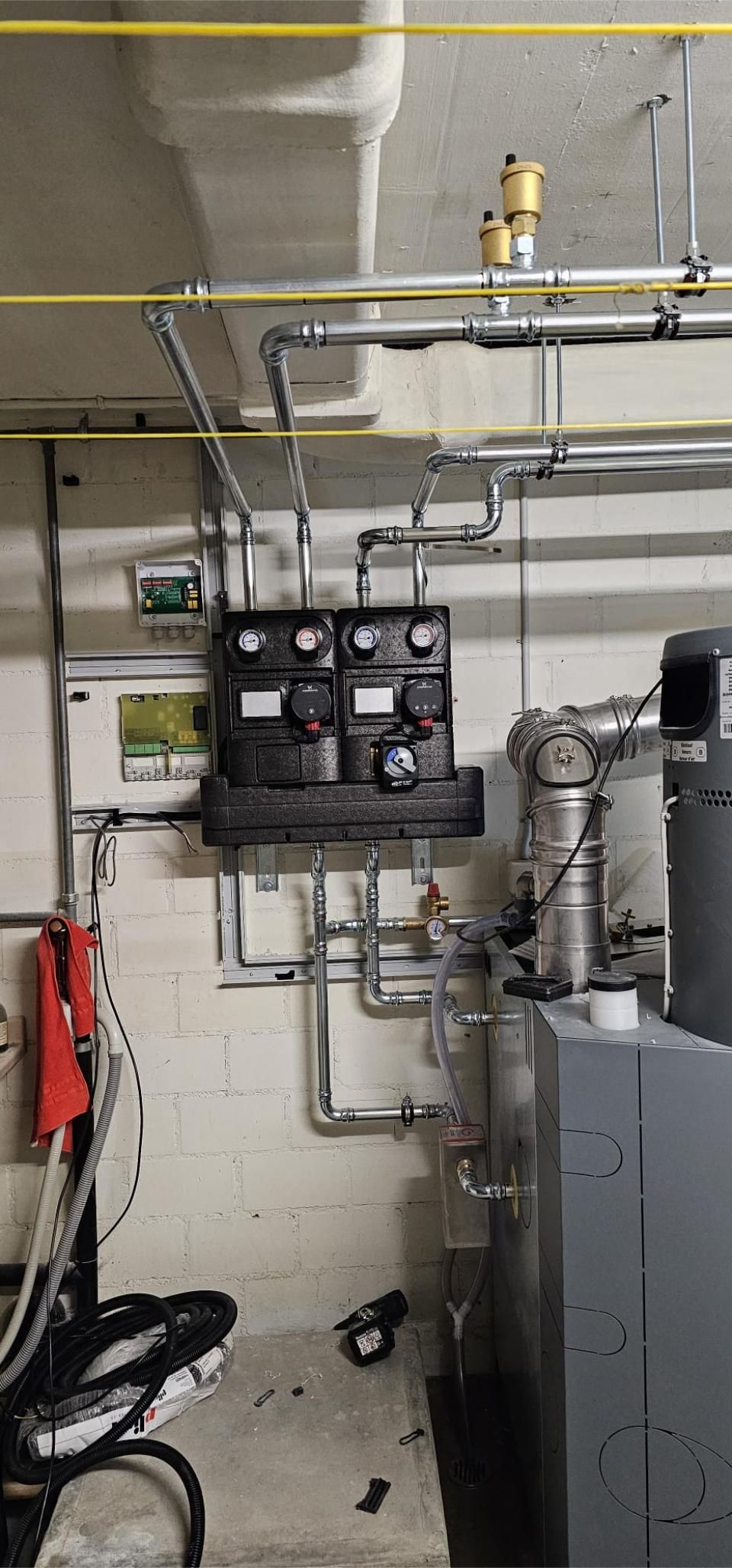 Ein Raum mit vielen Rohren, die von der Decke hängen. Foto von der MS Sanitär Heizung GmbH