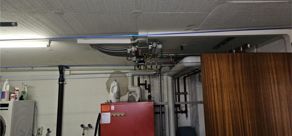 Ein Raum mit einer roten Heizung und einer Holztür. Foto von der MS Sanitär Heizung GmbH