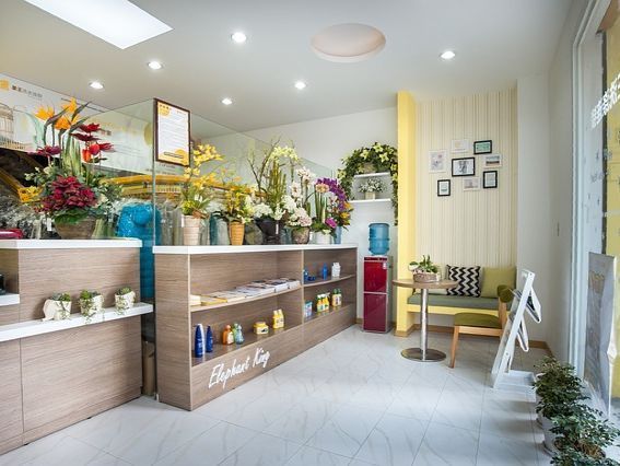 Una habitación con una mesa, sillas, estantes y flores.