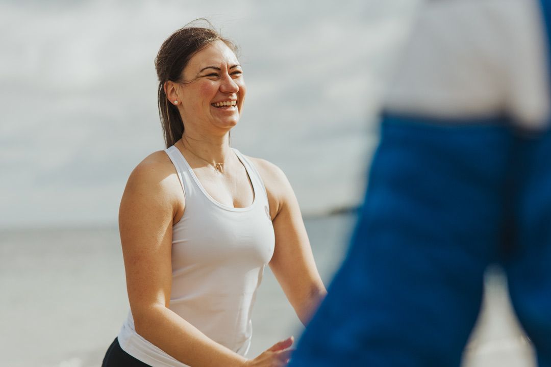 Eine Frau in Sportkleidung steht am Strand bereit für ihr Workout