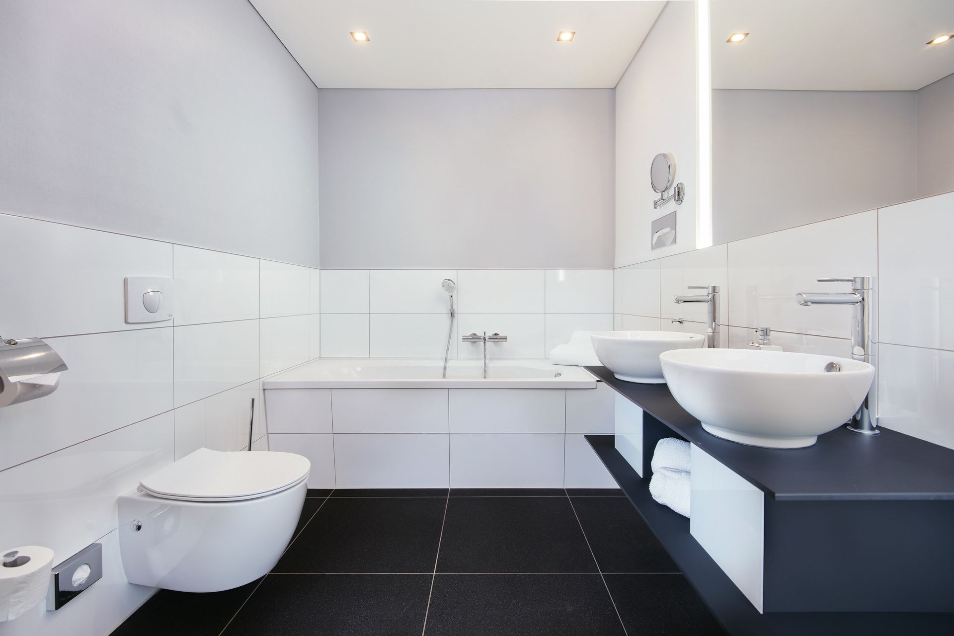 Ein Badezimmer mit zwei Waschbecken, einer Toilette und einer Badewanne.