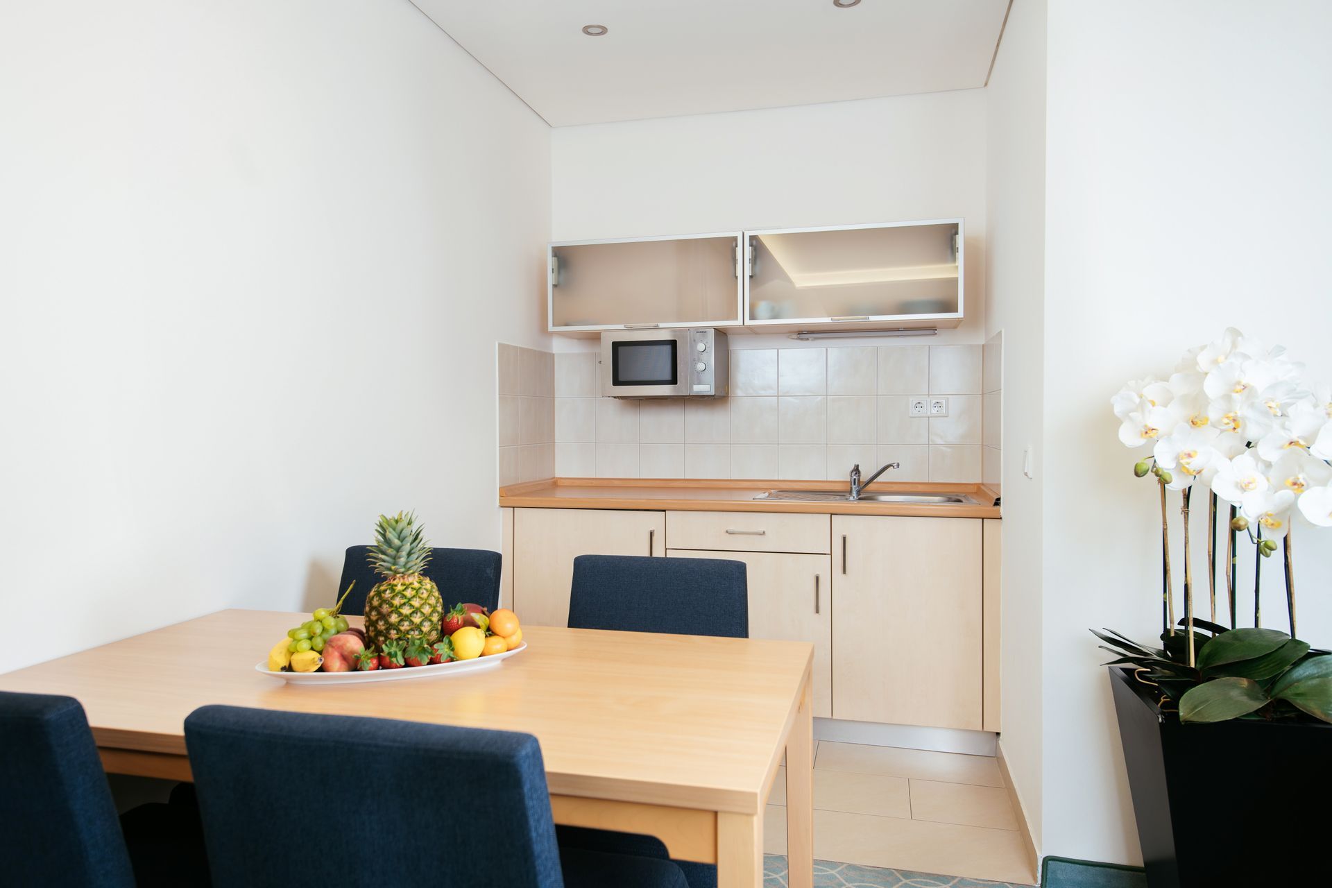 Eine Küche mit Tisch und Stühlen und einer Obstschale