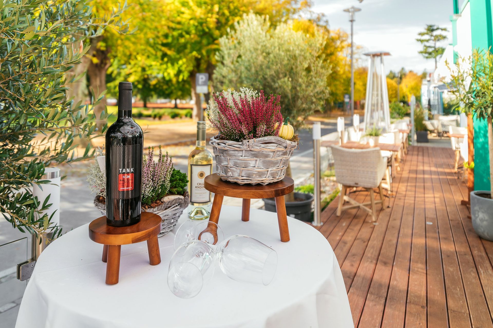 Eine Flasche Wein steht auf einem Holzhocker auf einem Tisch.