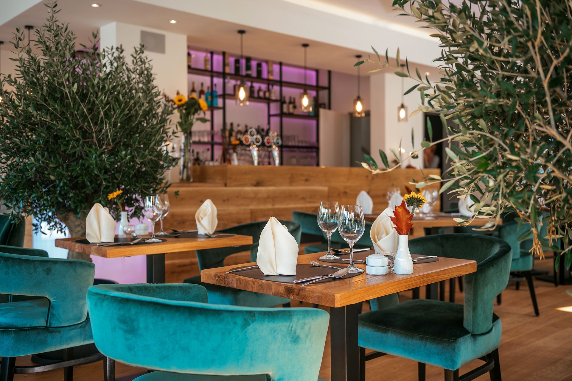 Ein Restaurant mit Tischen und Stühlen und einer Bar im Hintergrund.