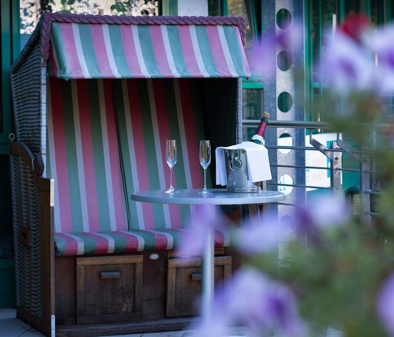 Ein gestreifter Stuhl mit zwei Gläsern und einer Flasche Champagner auf einem Tisch