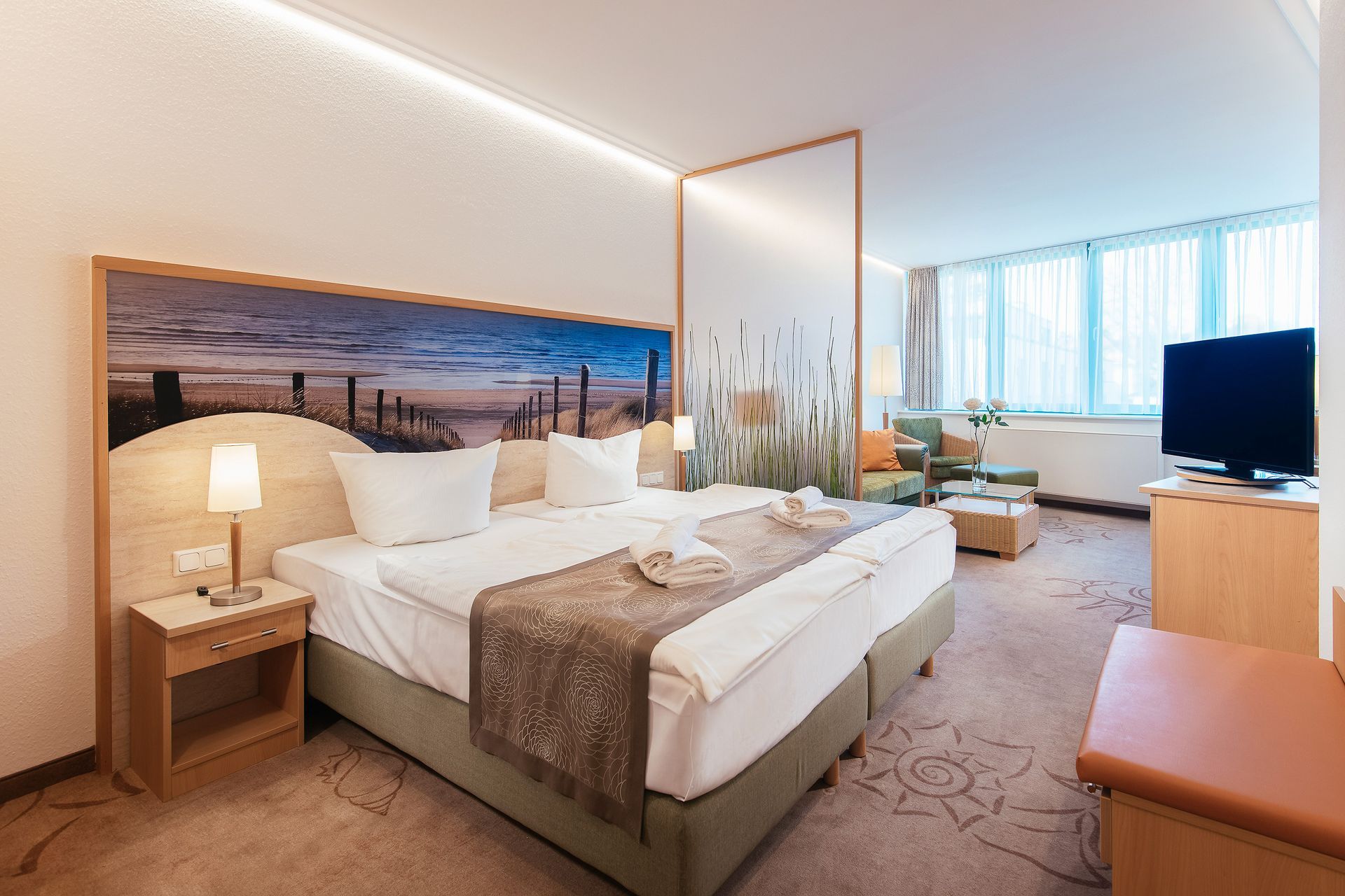 Ein Hotelzimmer mit einem großen Bett und einem Fernseher.