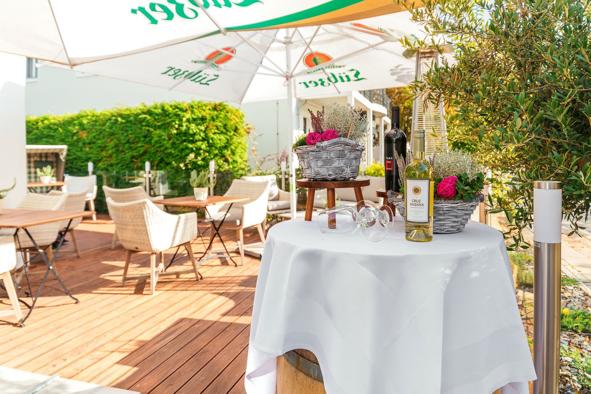 Ein Tisch mit einer weißen Tischdecke und einer Flasche Wein darauf.