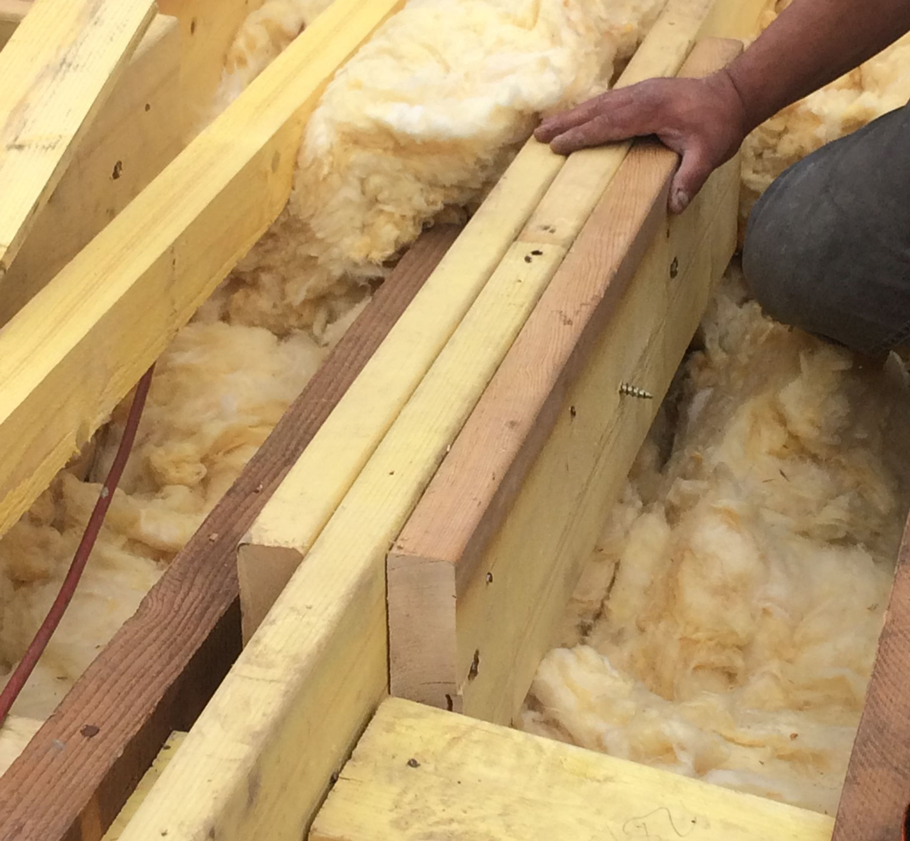 Une charpente et de la laine minérale.