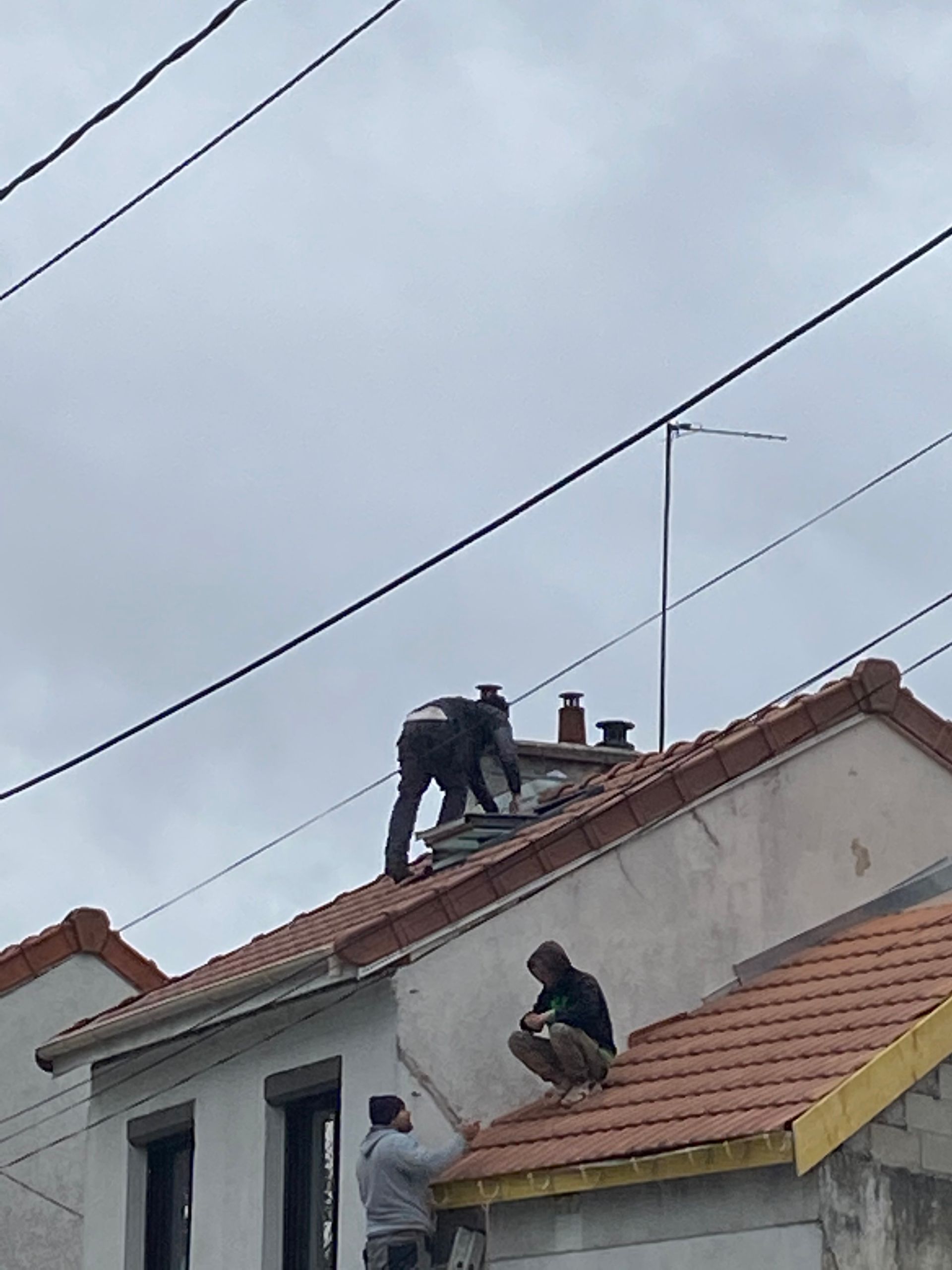 Deux couvreurs sur un toit.