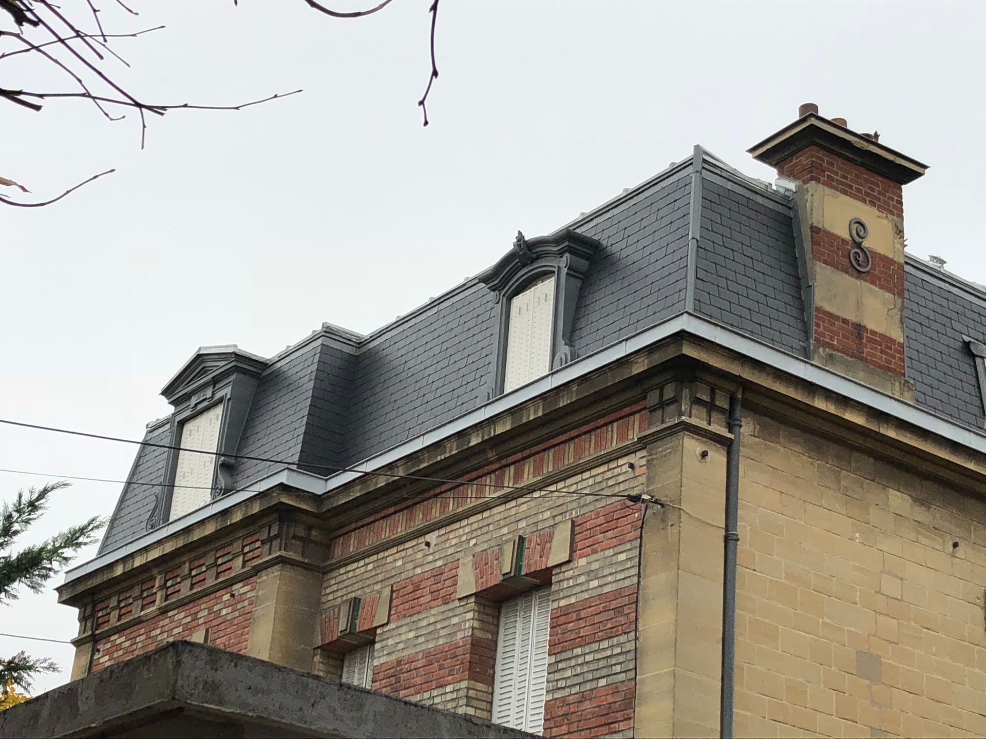 Une toiture en ardoises et deux fenêtres.