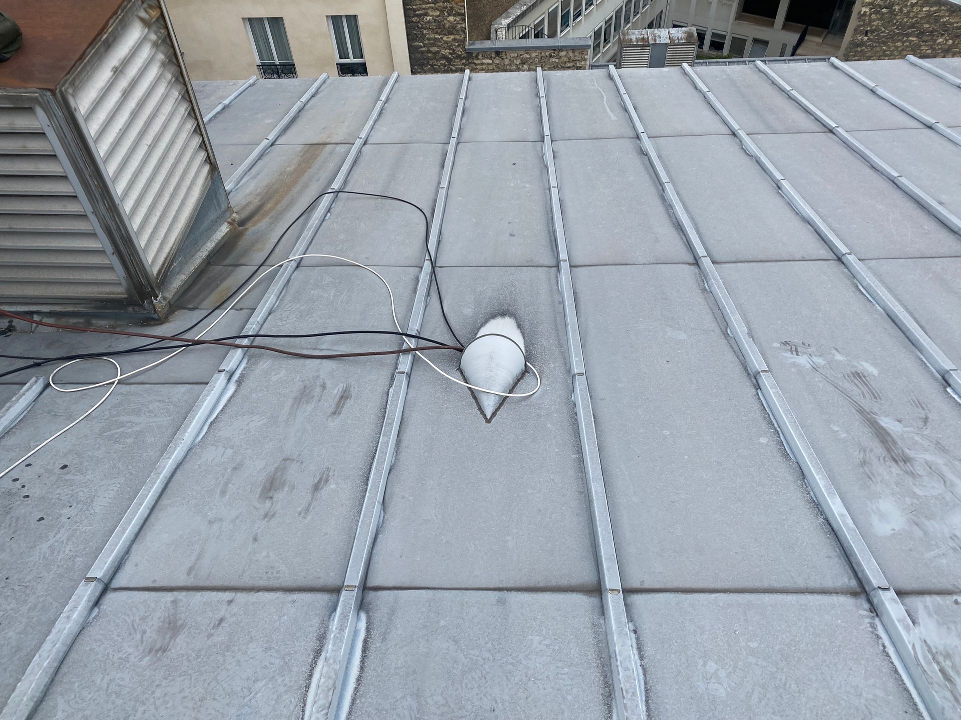 Une toiture en zinc avec des câbles.