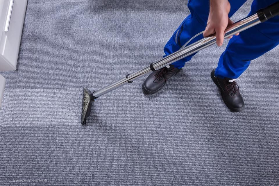 Multiline GmbH - Mann bei der Reinigung eines grauen Teppichbodens