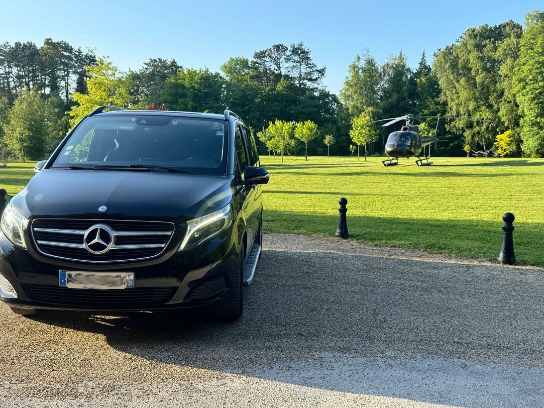 Un van noir avec un hélicopter en arrière plan
