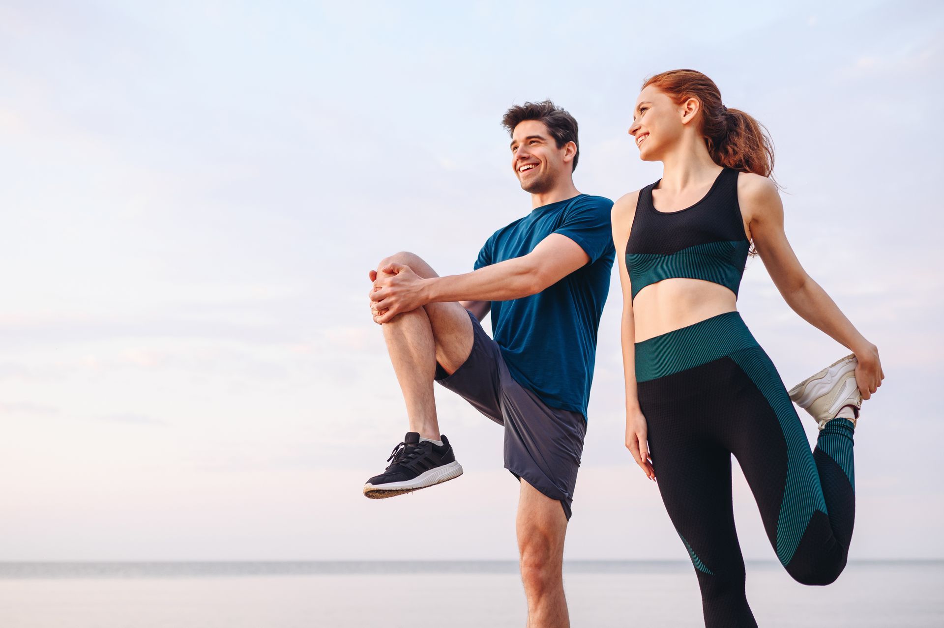 Un couple de sportifs exécutant des étirements.