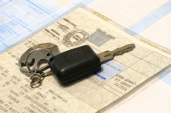Clé de voiture sur le titre de propriété et les documents d'immatriculation du véhicule.