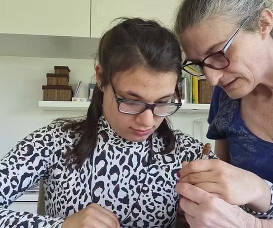 Deux personnes se tenant la main sur un canapé, l'une soutenant l'autre.
