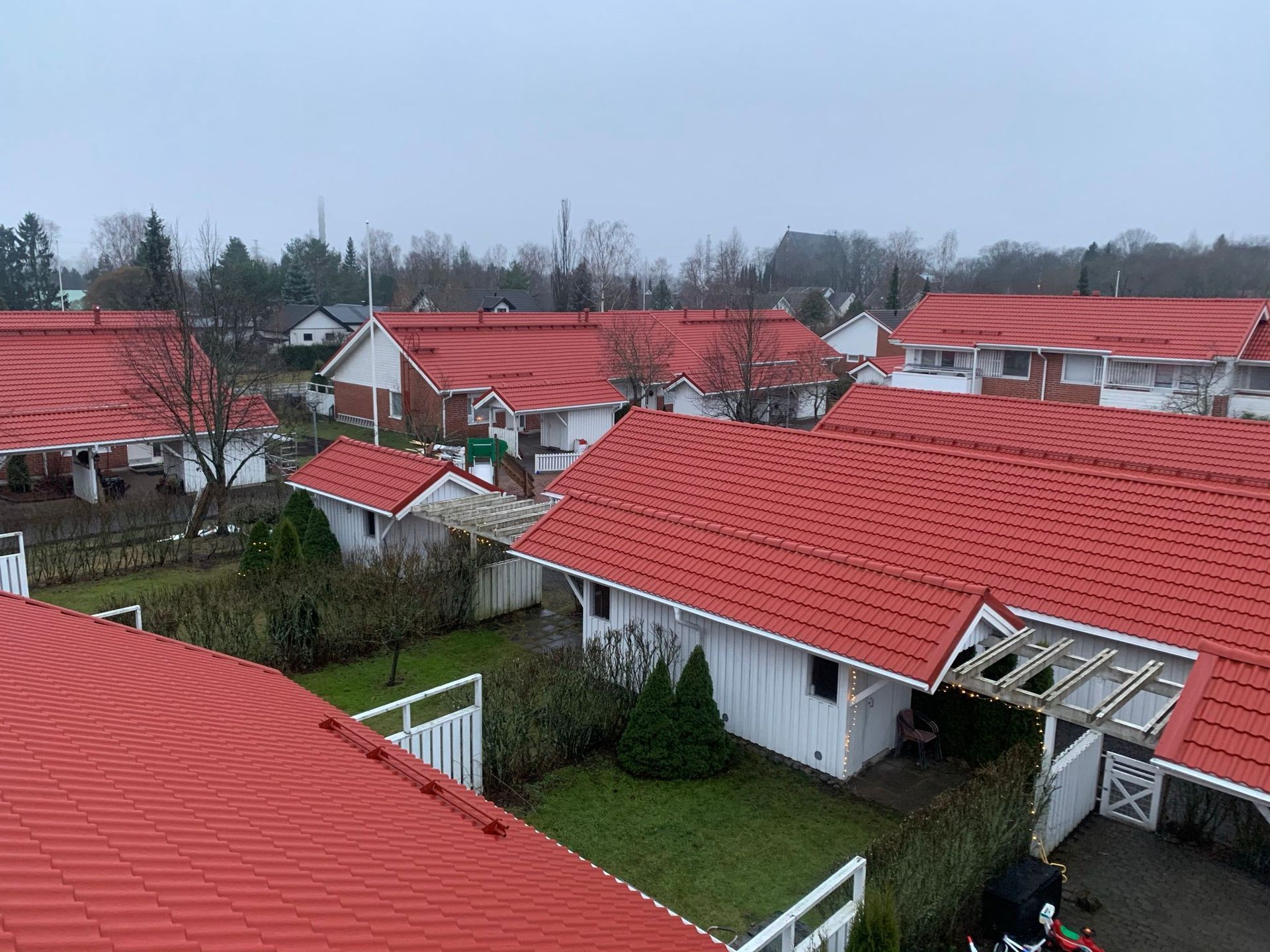 Punakattoisia taloja esikaupunkialueella pilvisenä päivänä