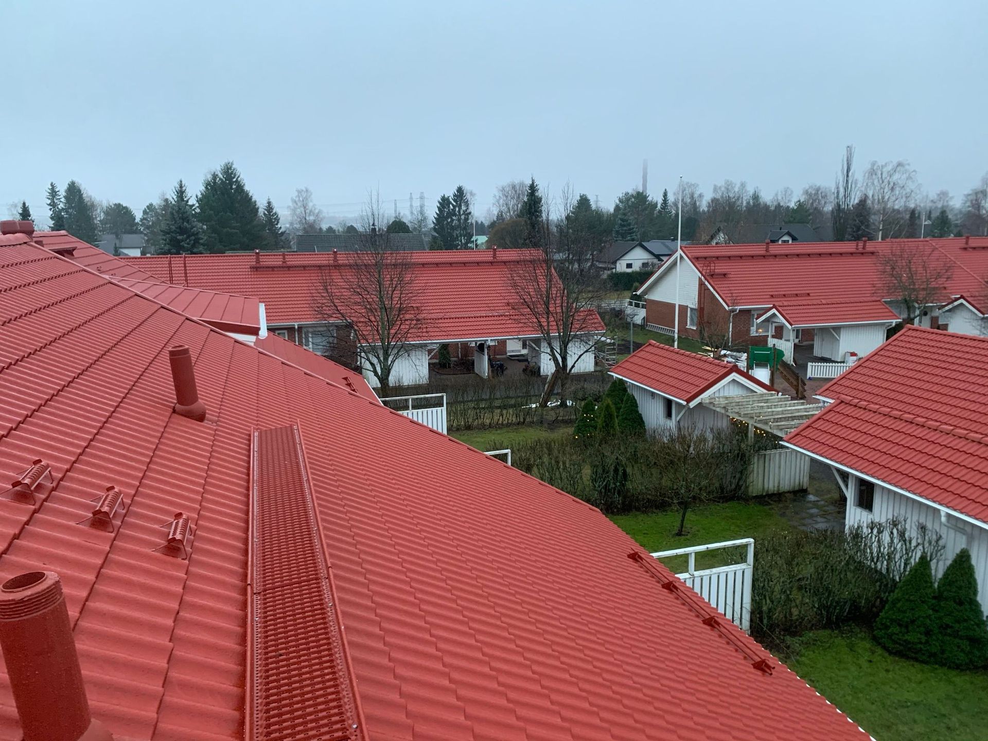 Punatiiliset katot esikaupunkialueella pilvisen taivaan alla