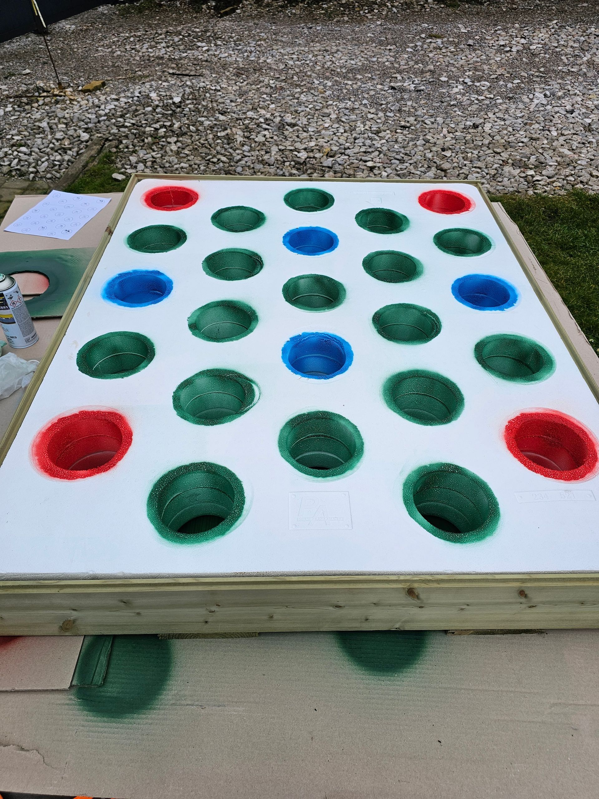 Grand plateau de jeu Twister d'extérieur avec des cercles rouges, verts et bleus sur fond blanc.