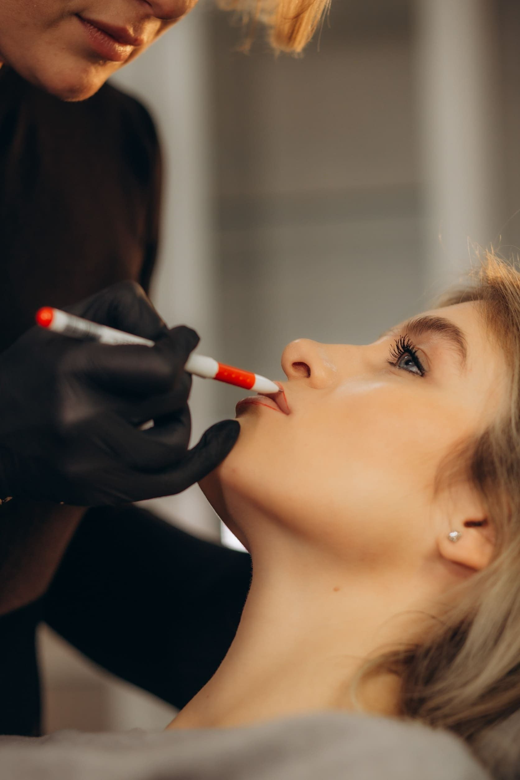 Una mujer se está haciendo un tatuaje en el labio con un marcador.