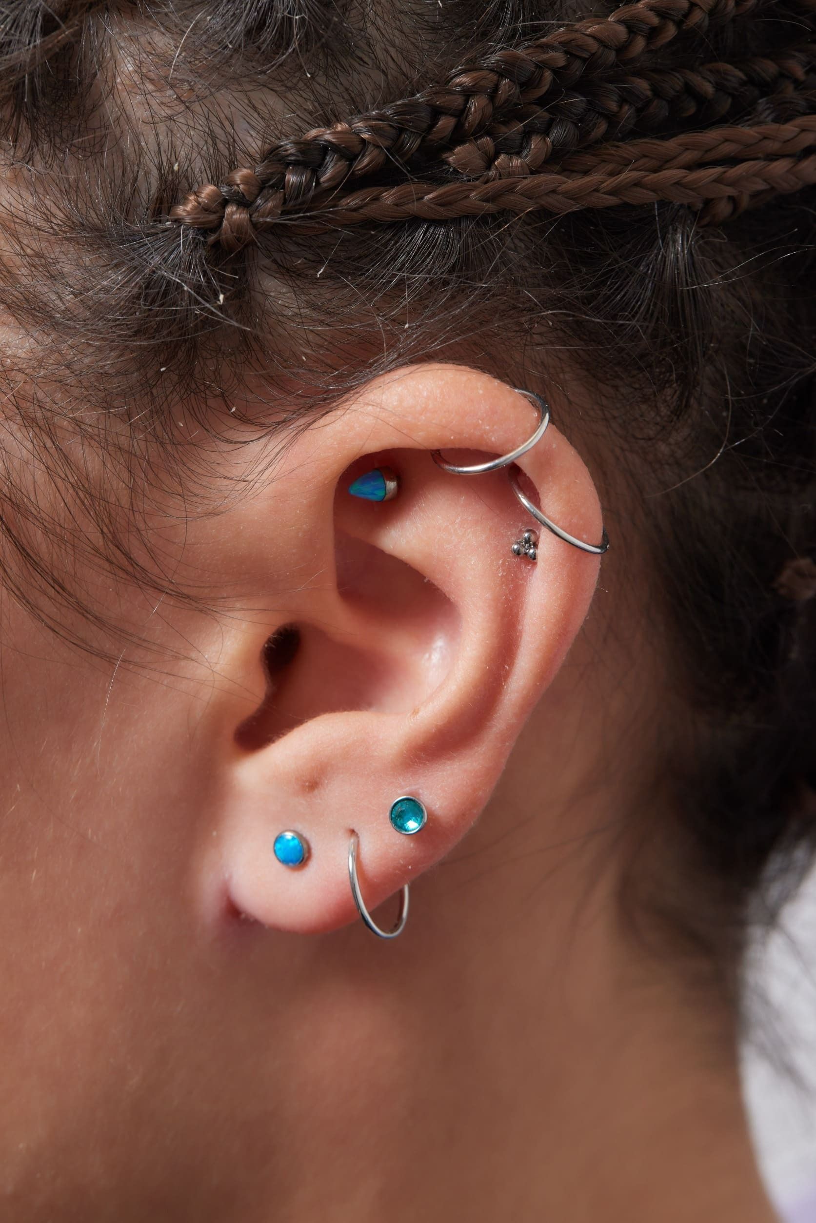 Un primer plano de la oreja de una mujer con múltiples perforaciones.