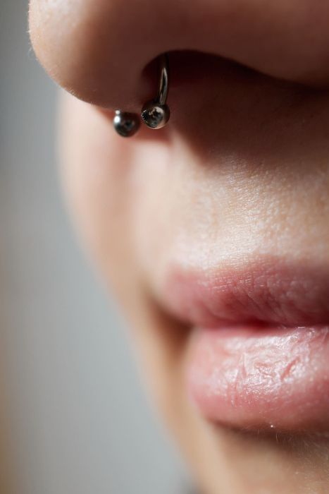 Un primer plano de la nariz de una mujer con un anillo en la nariz.