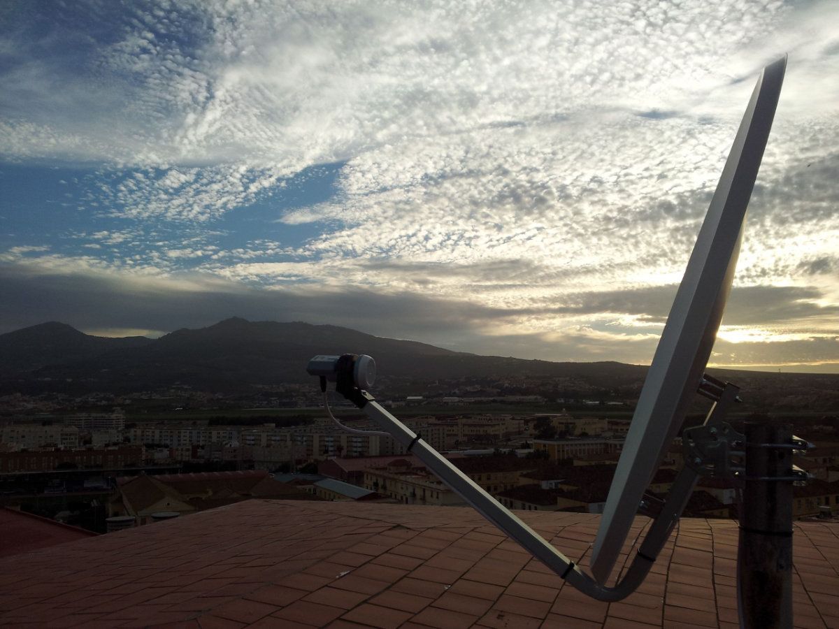 Una antena parabólica está colocada encima de un tejado.