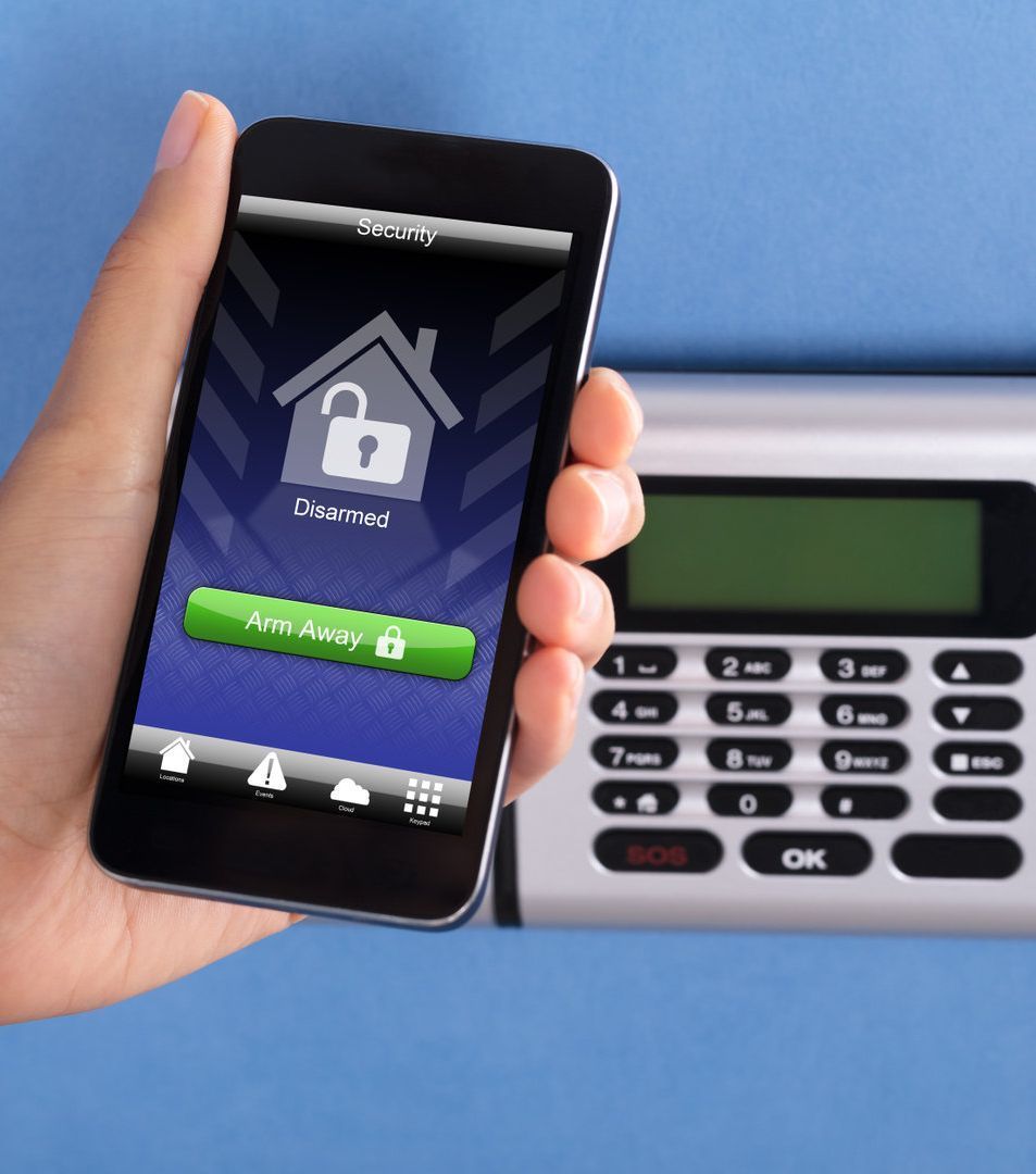 Una persona sostiene un teléfono inteligente frente a un sistema de seguridad.