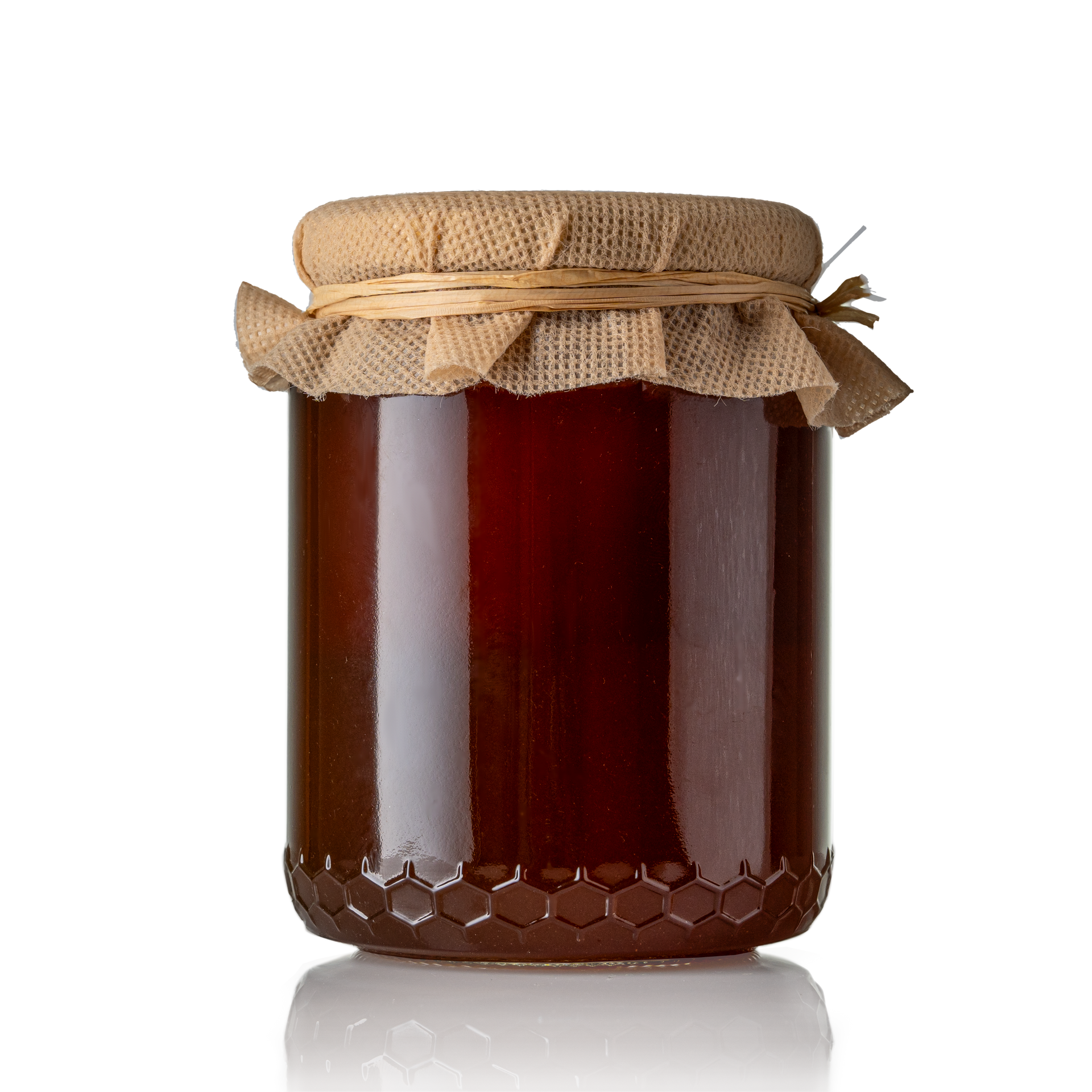 Un pot de miel foncé, recouvert d'un couvercle en toile de jute et fermé par une ficelle, sur un fond blanc.