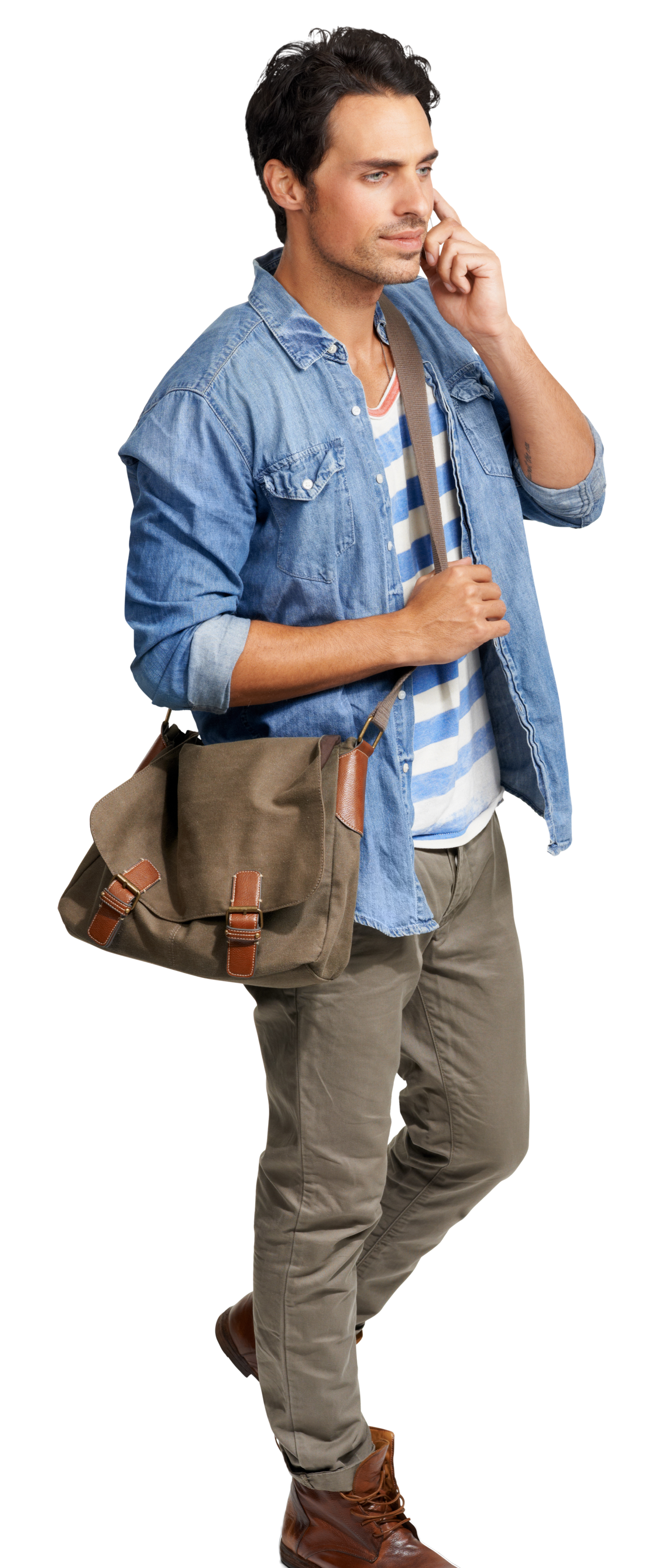 Une personne vêtue d'une chemise en jean et d'un haut rayé parle au téléphone tout en portant une sacoche marron.