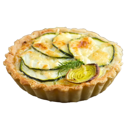 Une petite tarte salée aux légumes, composée de tranches de courgettes superposées et d'une garniture de poireaux sur une pâte dorée et cannelée.