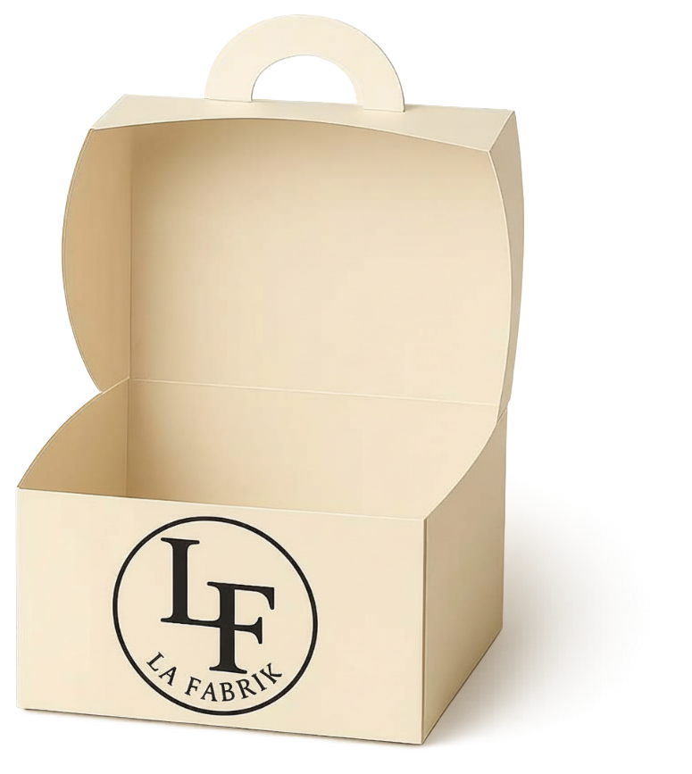 Une boîte en carton ouverte, de couleur crème, avec une poignée et un logo rond LF LA FABRIK sur le devant.