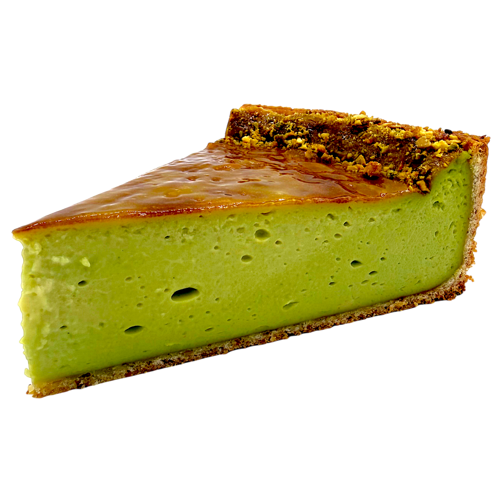 Une part de flan à la pistache, avec une croûte fine et caramélisée, sur fond blanc.