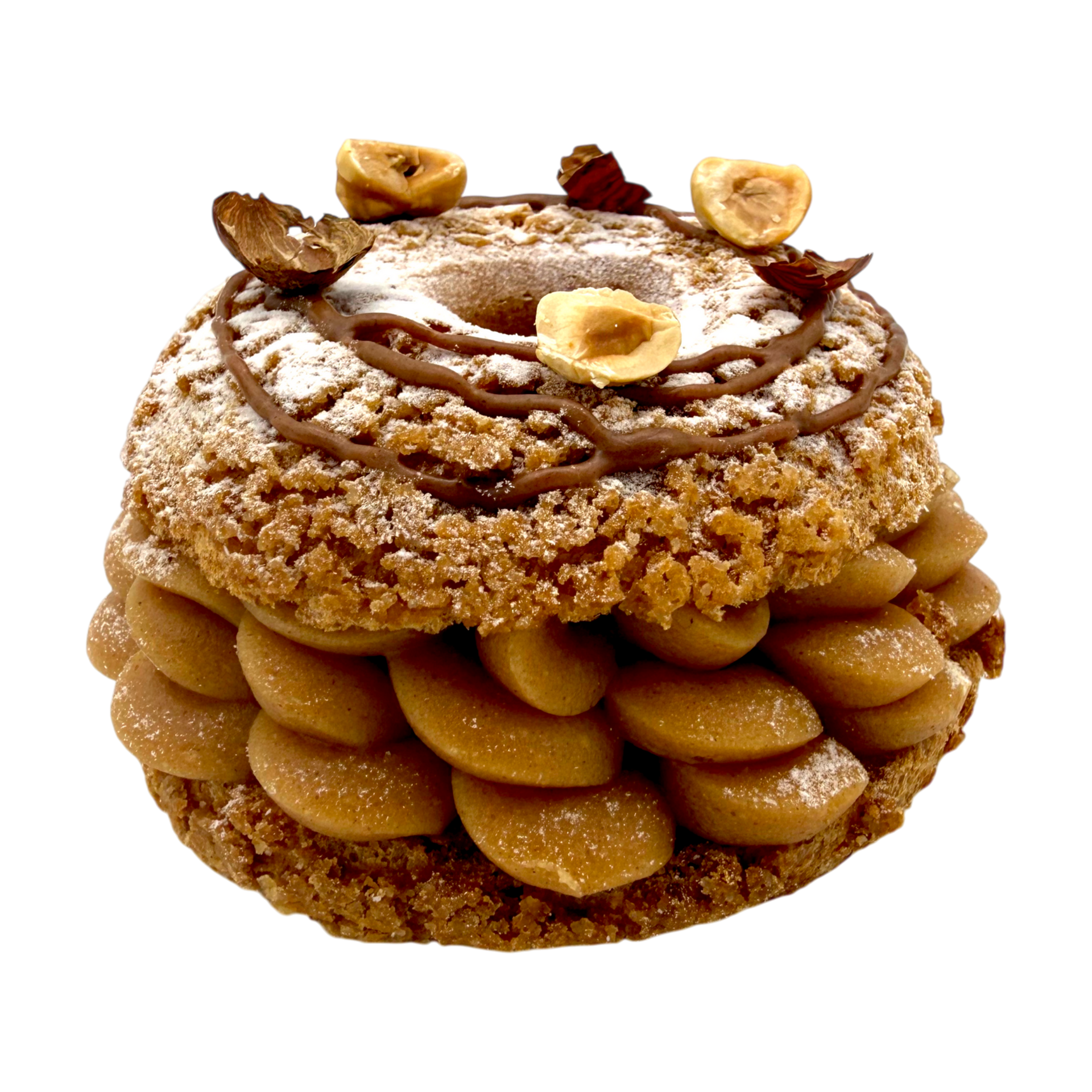 Un paris-brest aux noisettes garni de crème pralinée à la poche à douille, recouvert de noisettes et de sucre glace sur fond blanc.