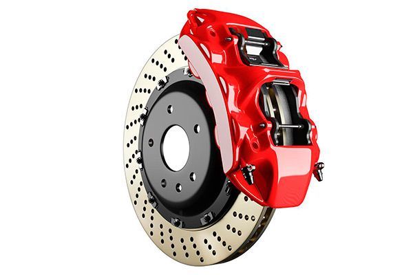 Pinza de freno roja con rotor ranurado, pieza del vehículo, sobre fondo blanco.