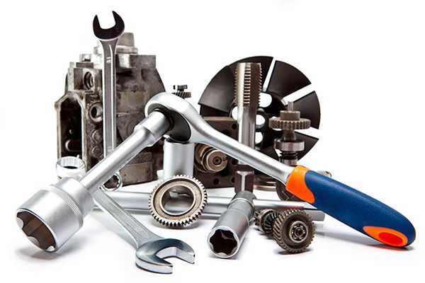 Llaves y piezas de automóvil sobre un fondo blanco; herramientas para reparación o mantenimiento.