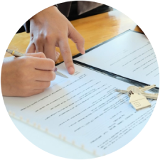 Una persona está escribiendo en un trozo de papel con un bolígrafo.