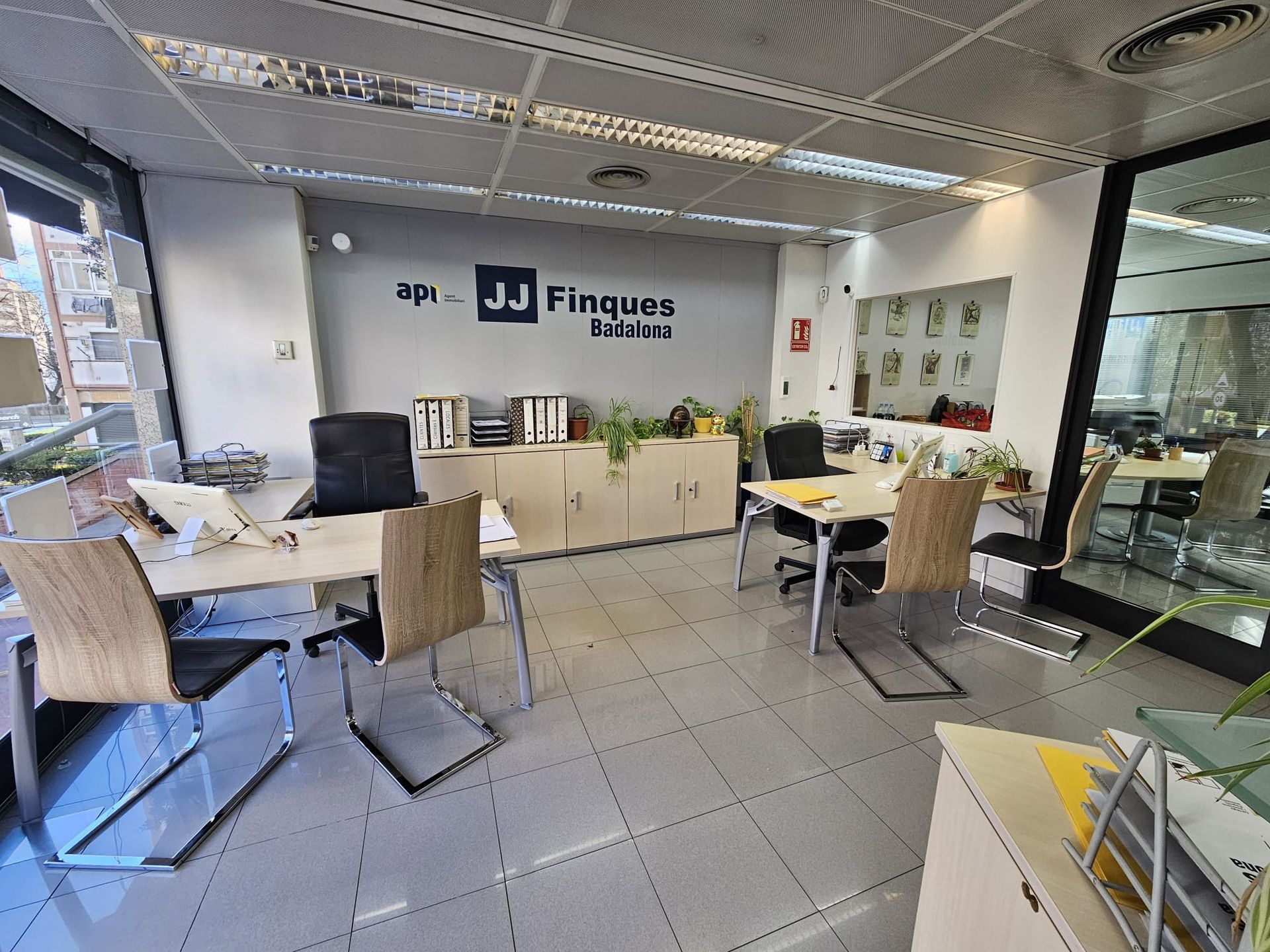 Una gran oficina con mesas y sillas y un cartel en la pared que dice jd finques