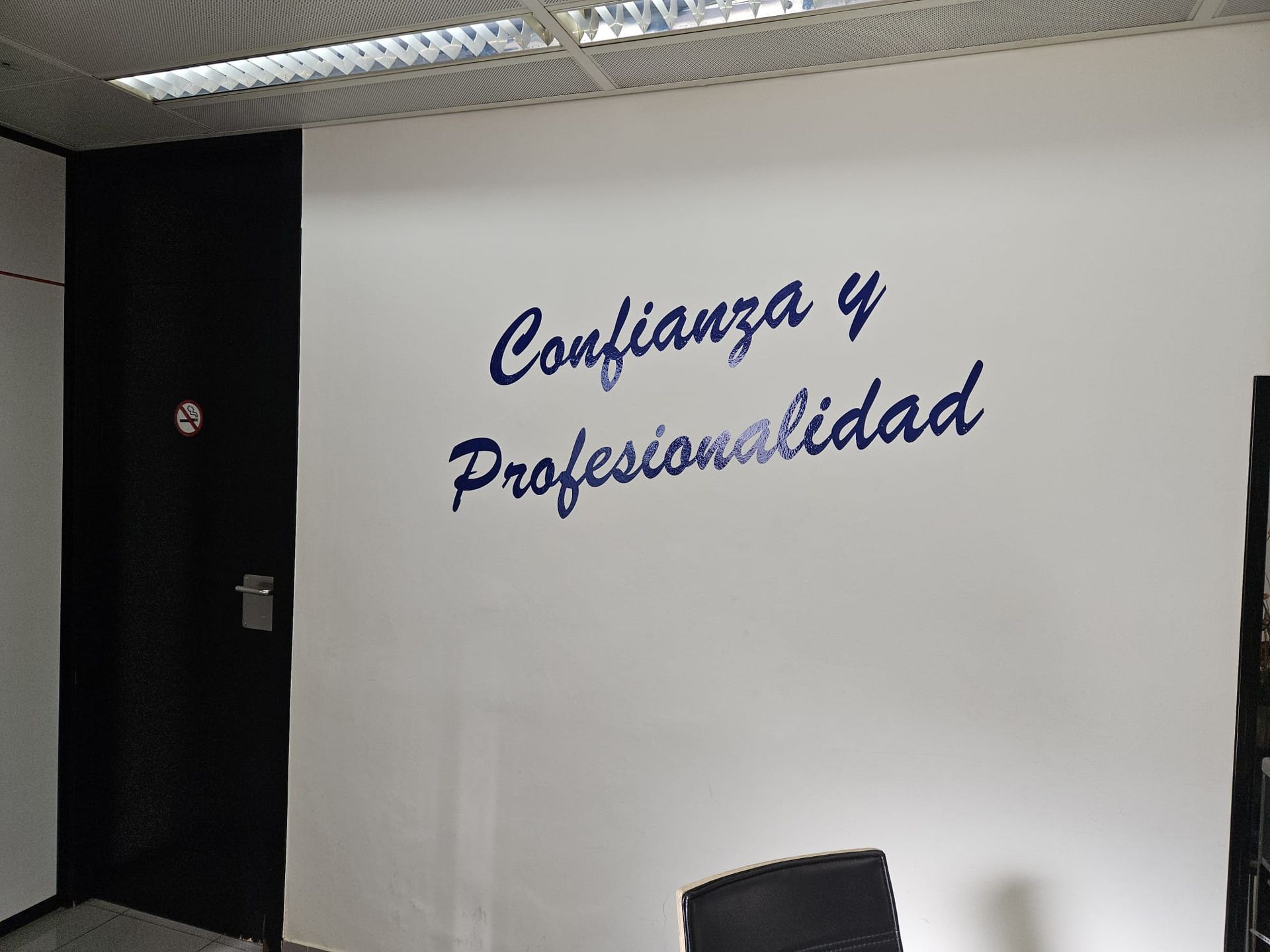 Una pared blanca con las palabras confianza y profesionalidad escritas en ella.