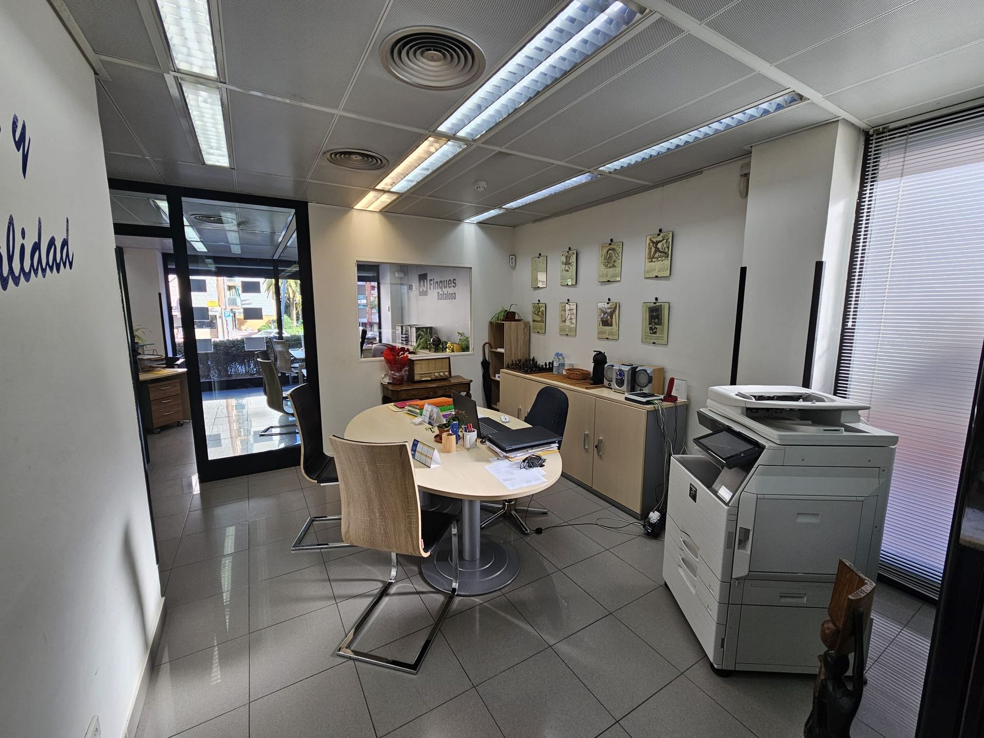 Una habitación con una mesa y sillas y una impresora.