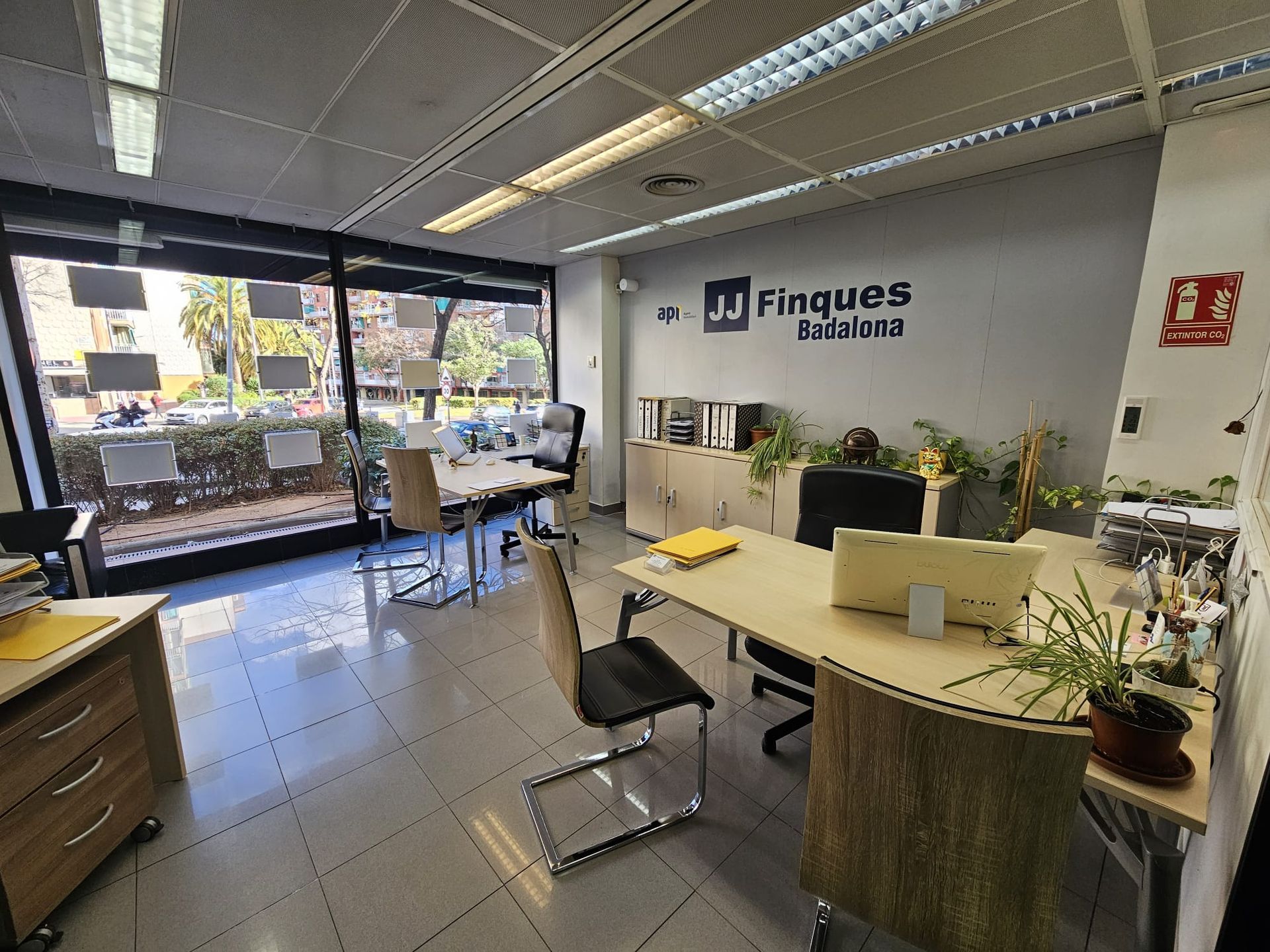 Una habitación con muchos escritorios y sillas y un cartel que dice finques