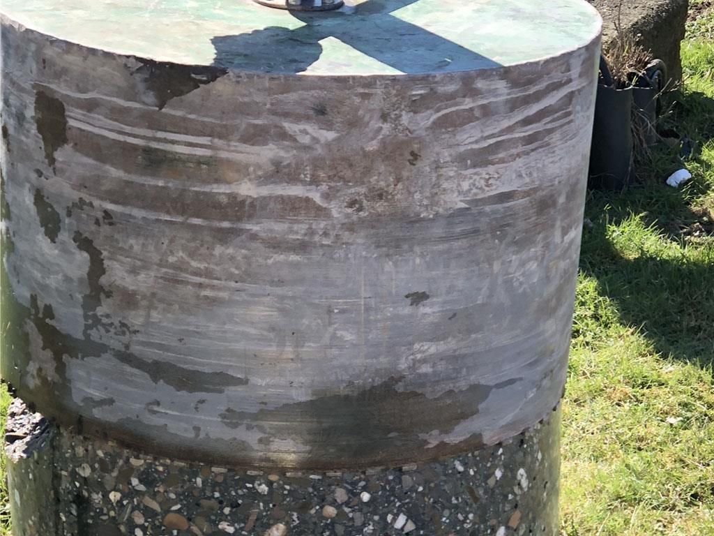 Ein großes zylindrisches Objekt liegt im Gras.