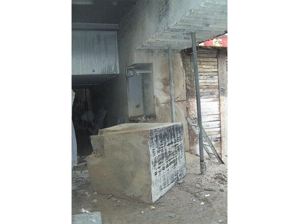 Ein großer Betonblock steht vor einem Gebäude